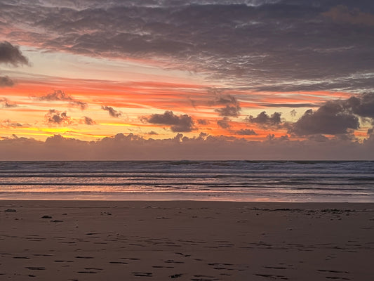 a view of a sunset from a cornish beach