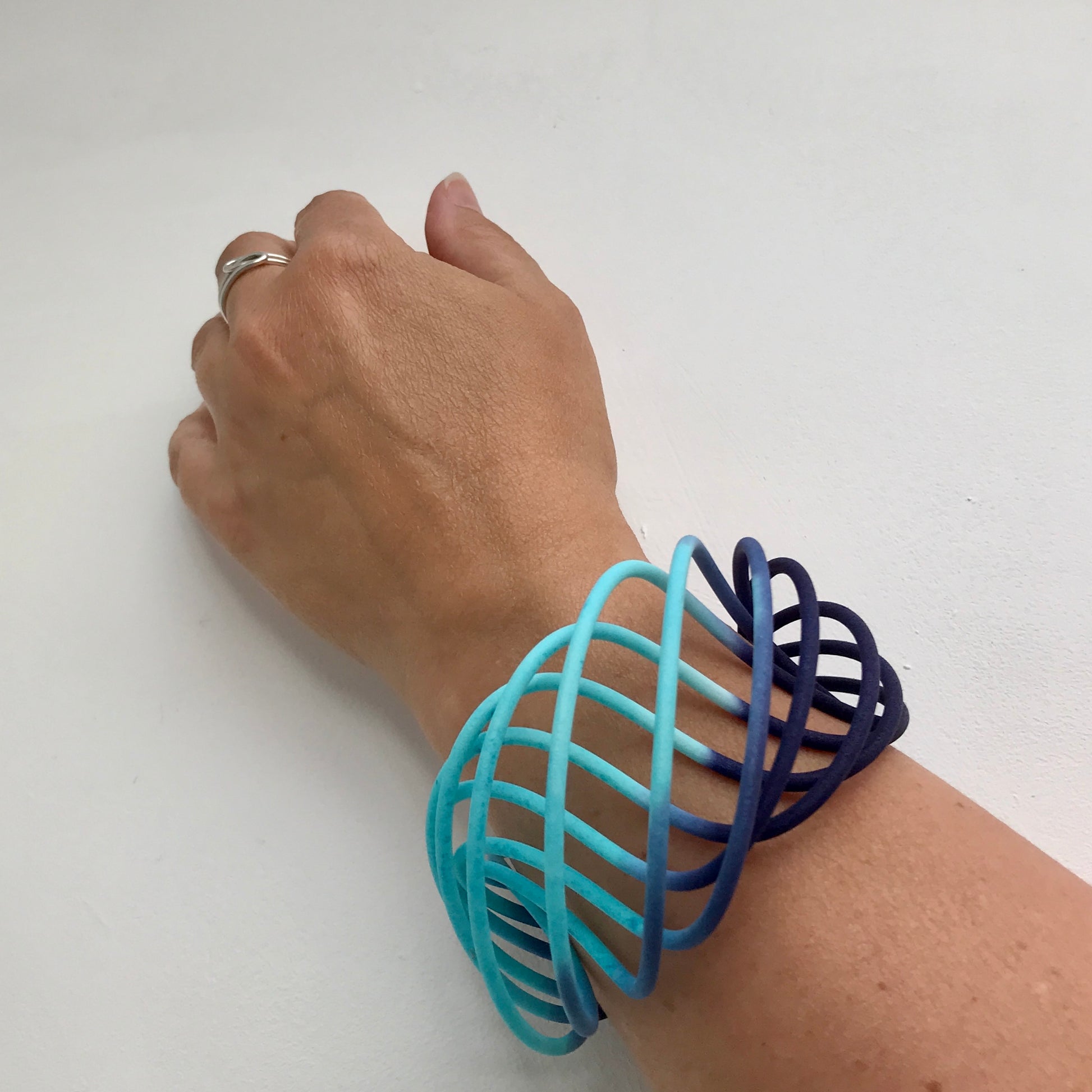 Turquoise Blue fade wide vortex bangle on model with Loop ring