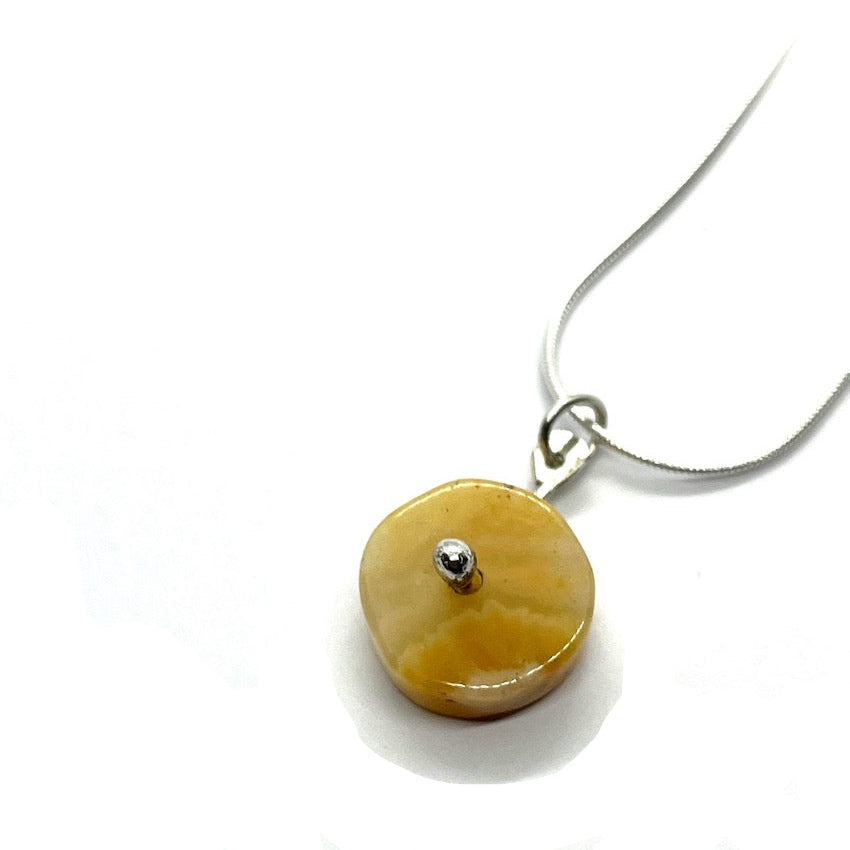 yellow agate pendant on a chain on a white background
