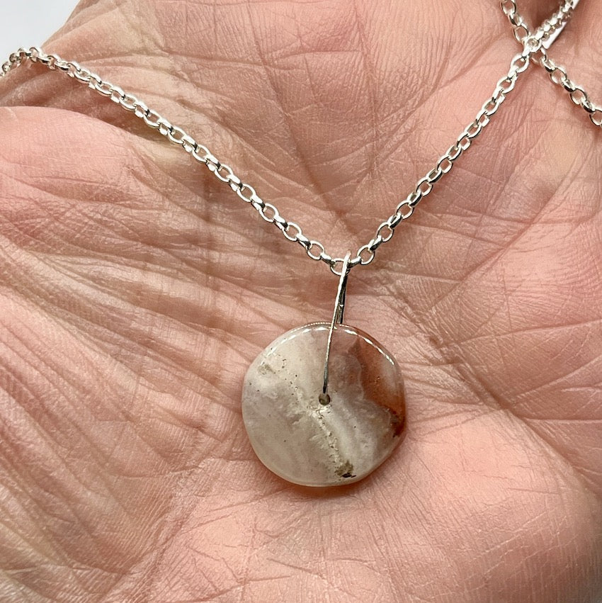 small agate pendant in palm of hand
