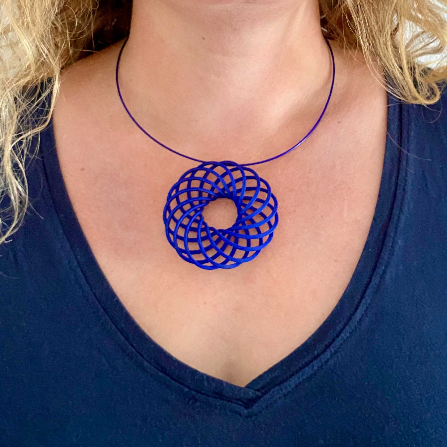 Katy wearing the large blue 3D printed vortex pendant by Katy Luxton