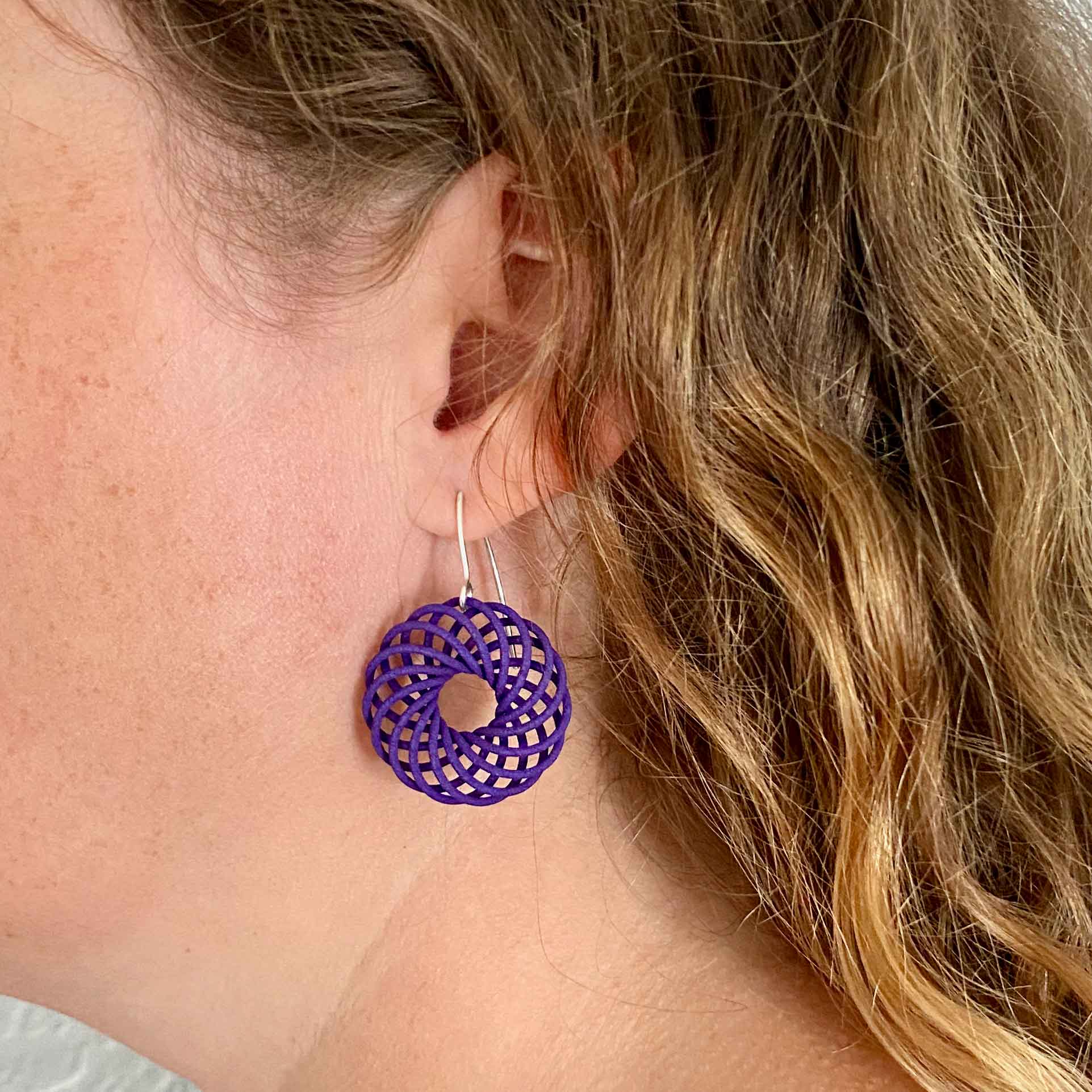 Katy wearing small purple Vortex 3D printed nylon earrings
