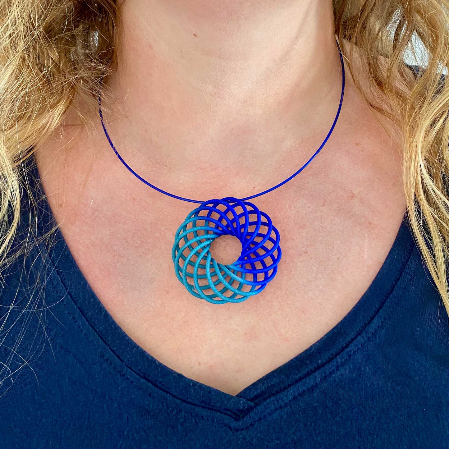 Katy wearing the Vortex 3D printed nylon pendant in blue to teal fade colour way